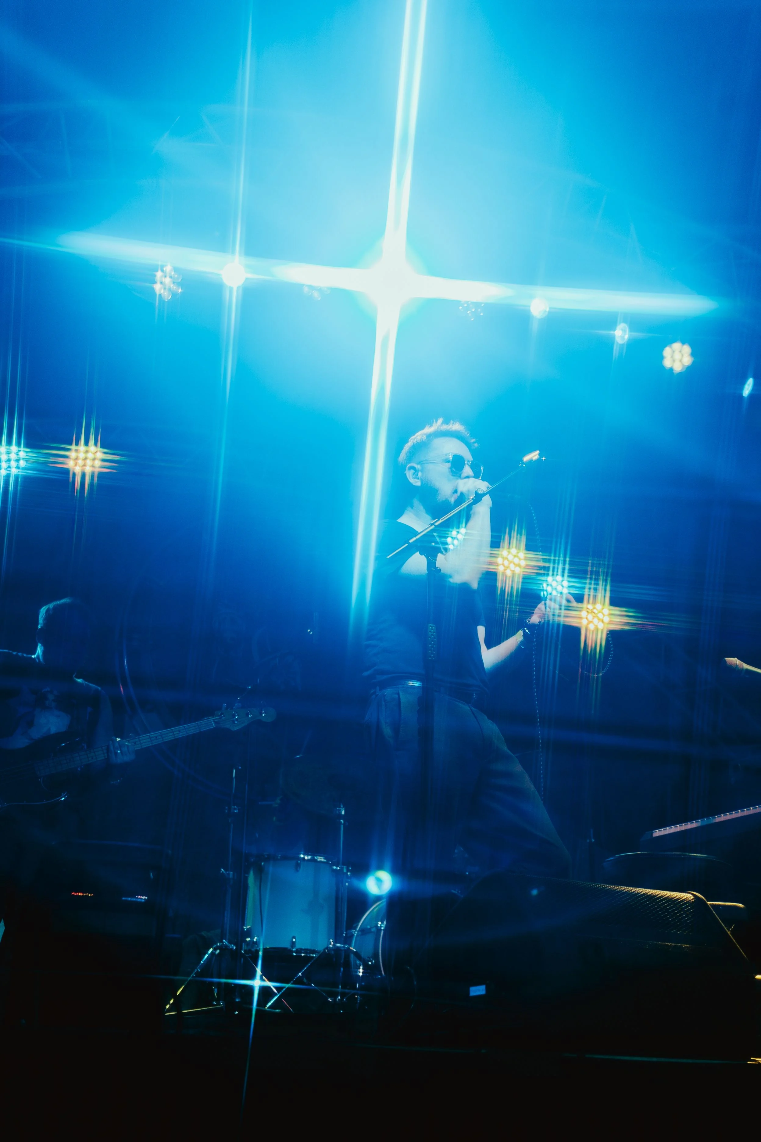 Scott singing beneath blue stage lights