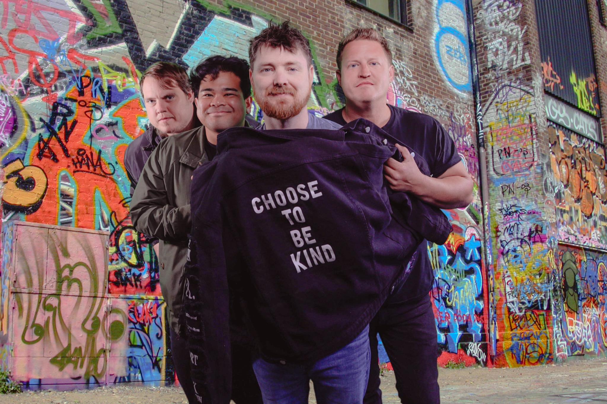 Back To The Start band in front of a colorful graffiti wall